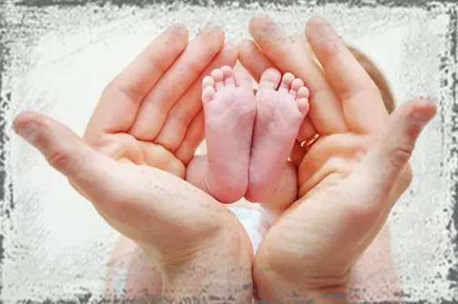 StandUpGirl hands hold two baby feet