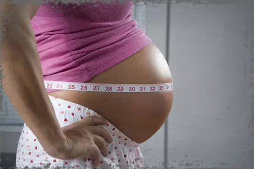 StandUpGirl pregnant belly with tape measure around it