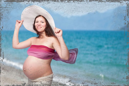 StandUpGirl pregnant woman on beach with hat