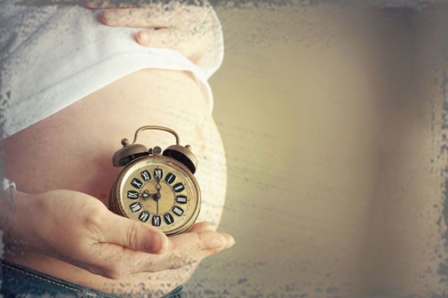 StandUpGirl clock held up to pregnant belly