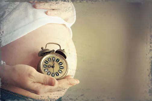 StandUpGirl clock held up to pregnant belly