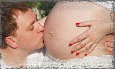 StandUpGirl man kisses pregnant belly