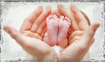StandUpGirl hands hold baby feet